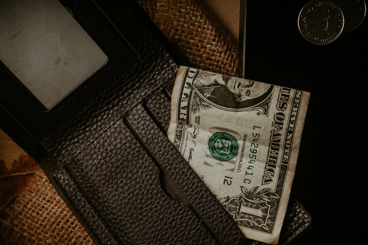 Wallet holding a one dollar bill and coins