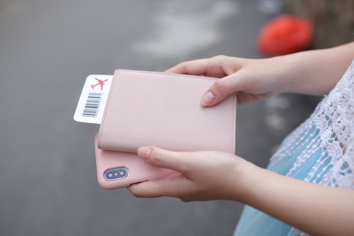 Traveler holding a phone, passport and boarding pass