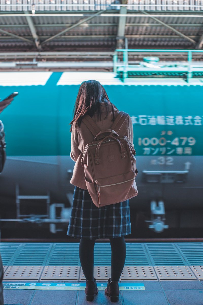 Commuter with a backpack waiting at a train platform
